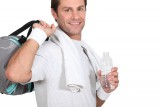 Man holding gym bag, water, towel, and wearing sweat bands