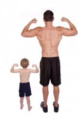 Father and son with backs to the camera flexing their biceps