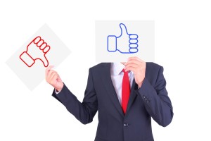 Businessman swap paper to show the contrast of thumbs up and thumbs down