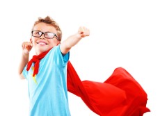 Little boy in glasses dressed up as a superhero